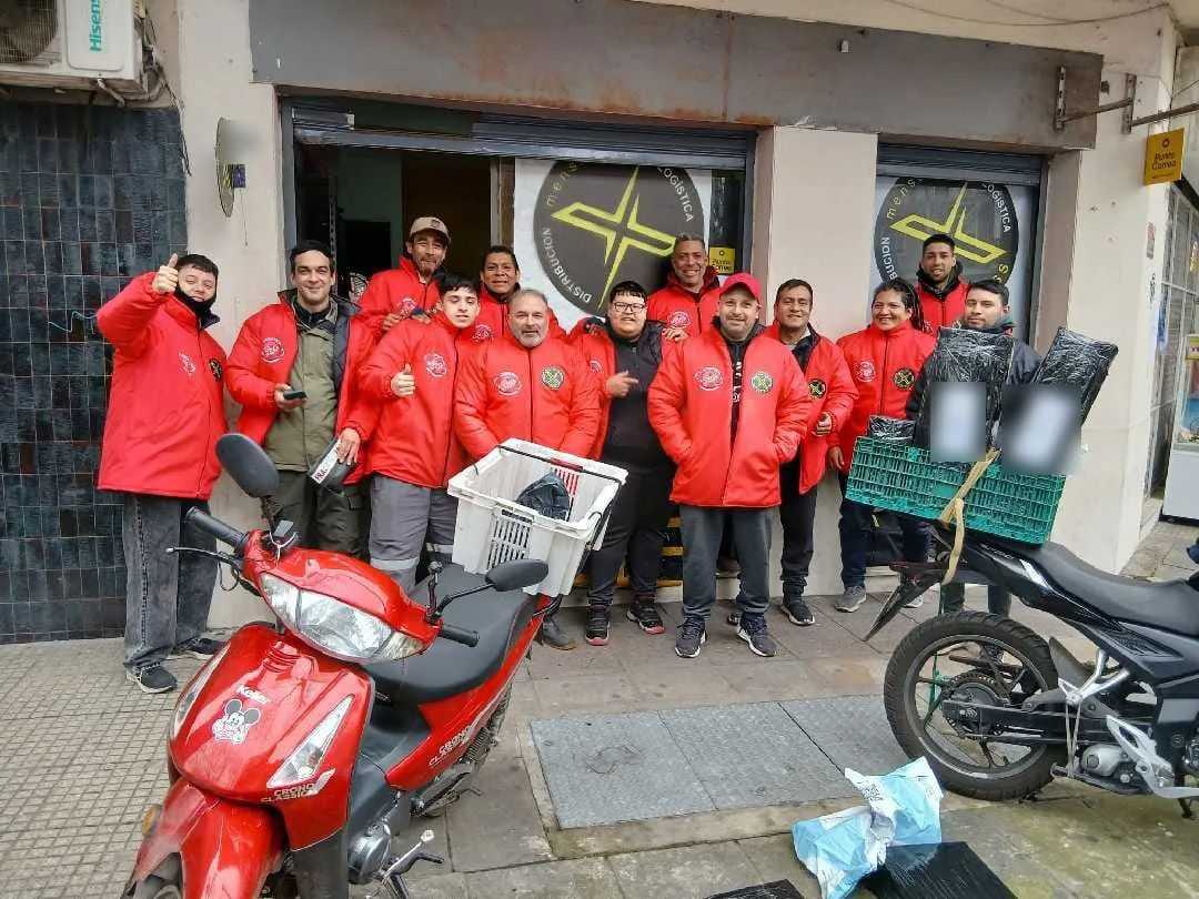 Equipo y repartidores de Logística Norte con sus motos frente al local